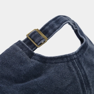 Detail of adjustable brass metal buckle and navy twill fabric on the baseball cap