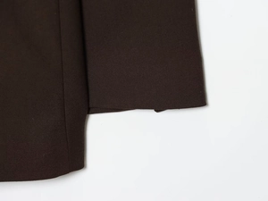 Detailed macro view showing the fine twill texture of the dark brown suit fabric