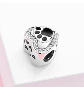 Macro detail of heart-shaped S925 silver paw print charm with pink enamel and crystals