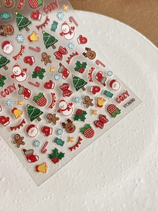 Detail view of 3D embossed Christmas nail stickers featuring Santa and tree patterns