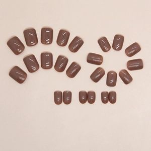 Glossy caramel brown press-on nails in various sizes on a neutral background