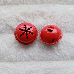 Detailed view of red hollow star and snowflake metal bells on white faux fur background