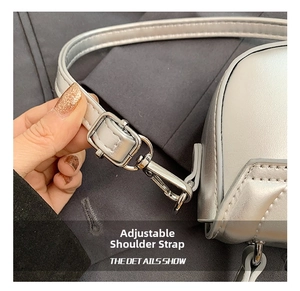 Detail of adjustable silver shoulder strap with metallic hook on a stylish kids crossbody bag