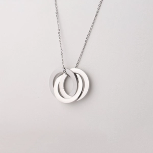 Close-up of interlocking triple ring pendant in polished stainless steel on a thin O-chain