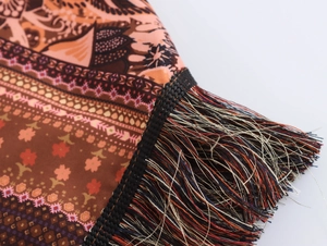 Gros plan sur un tissu à motif tribal bohème avec des détails de franges à glands colorés