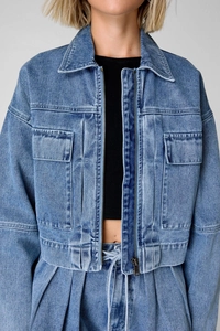 Close-up of blue denim cargo jacket and matching pants showing fabric texture and seams