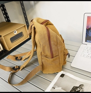 Seitenansicht eines braunen Vintage-Leinenrucksacks mit Reißverschluss und Seitentasche