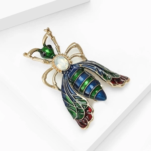 Colorful enamel bee brooch with iridescent gemstone on gold metal base and rhinestones