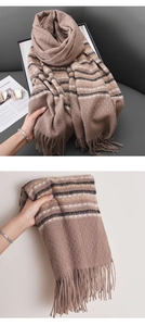 Detail of soft camel cashmere-like scarf with black stripes and fringe tassels