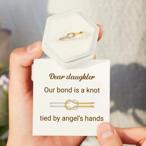 Detail of two-tone knot ring in white velvet gift box with daughter sentiment card