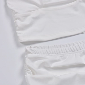 Detailed view of white knitted fabric texture and elastic waistband with fine stitching