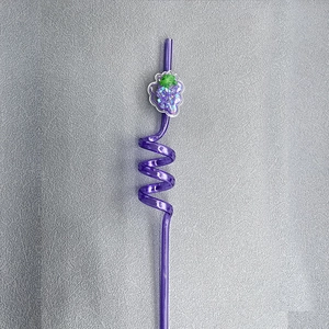 Detail of purple spiral reusable straw featuring a glittery grape shaped charm pendant