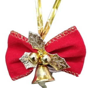 Close-up of a red velvet Christmas bow with gold stitching, metallic leaves, and a small bell