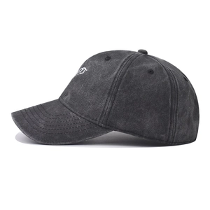 Detail view of washed dark grey cotton baseball cap with white embroidery and retro texture