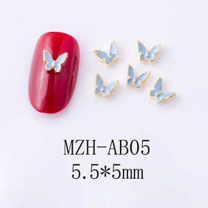 Macro detail of 5.5x5mm light blue alloy butterfly nail art charms with gold metal edges