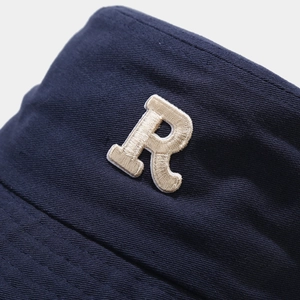 Dark blue cotton bucket hat with textured R letter embroidery and sun protection brim