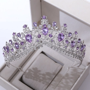 Close-up of a silver bridal crown with purple crystals and rhinestones in a velvet box