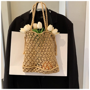 Detail of hand-woven beige tote bag with hollow mesh texture and sturdy rope handles