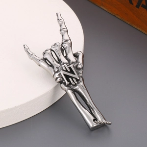 Close-up of a silver stainless steel skeleton hand pendant with rock sign gesture
