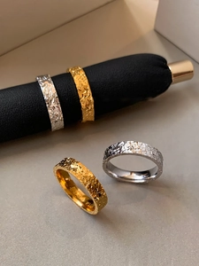 Macro shot of 18k gold and silver hammered rings featuring detailed interior engraving