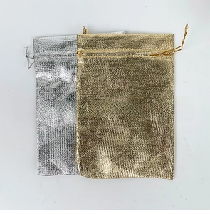 Detail of metallic woven gold and silver jewelry pouches with drawstring closure