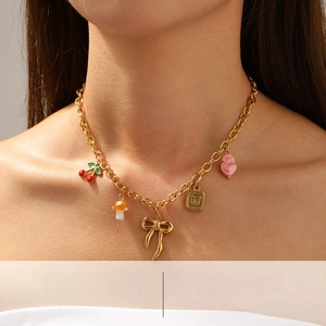 Detail of chunky gold chain necklace featuring colorful cherry, mushroom, and heart charms