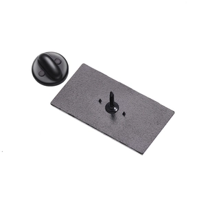 Detail view of the black metal brooch back with sturdy pin and rubber clutch closure
