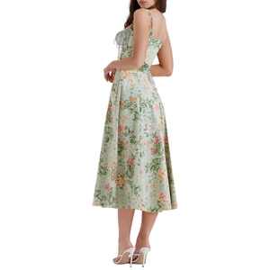 Detail view of the light green floral strap dress with orange and white flower patterns