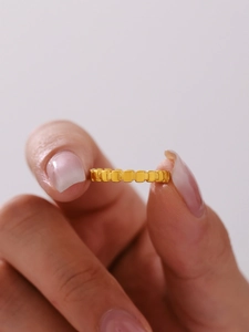 Gros plan d'une bague dorée en acier inoxydable avec motif géométrique de carrés