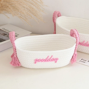 Detail of white cotton rope basket featuring pink Good Day lettering and side handles