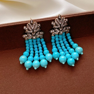 Nahaufnahme von Vintage-Quastenohrringen mit blauen Türkisperlen und Strass-Blattstecker
