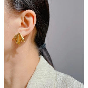 Artistic gold crinkled geometric earrings worn by a model for a minimalist fashion look
