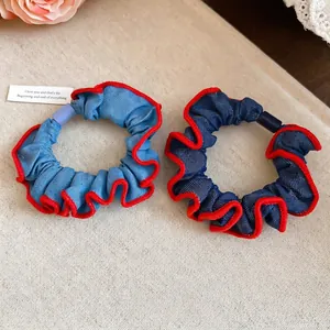 Denim fabric hair scrunchies in light and dark blue with red contrast wavy edges