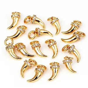 Polished gold horn charms with micro-paved cubic zirconia accents on white background
