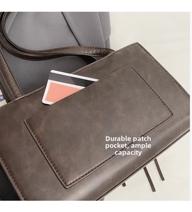Detail of a dark brown suede shoulder bag featuring a functional external patch pocket