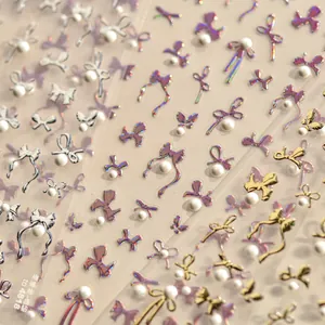 Macro detail of 3D bow nail stickers with pearls in gold and silver finish