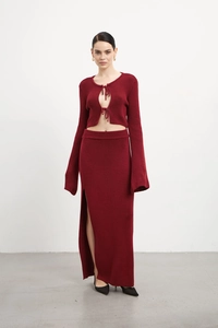 Détail d'un ensemble en tricot bordeaux avec haut à lacets et jupe fendue à taille haute