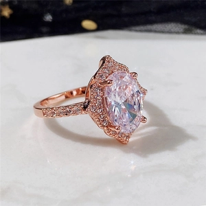 Macro shot of rose gold ring with large oval zircon and detailed pave setting on marble