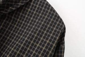 Detailed macro view of woven plaid fabric texture in dark brown and black check pattern