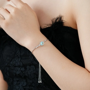 Detail of adjustable silver bracelet featuring a square sea blue gemstone and side diamonds