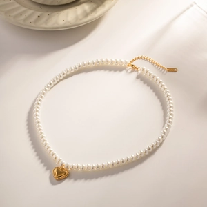 Detail of 18k gold heart pendant with white pearls and adjustable lobster clasp chain