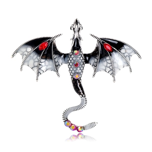 Detailed macro of vintage dragon brooch with enamel wings and vibrant rhinestones