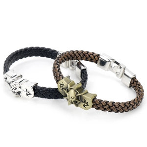 Close-up of black and brown braided leather bracelets with skull charms
