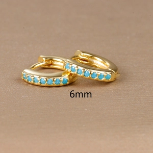 Macro view of 6mm golden huggie earring with inlaid light blue turquoise zircon stone