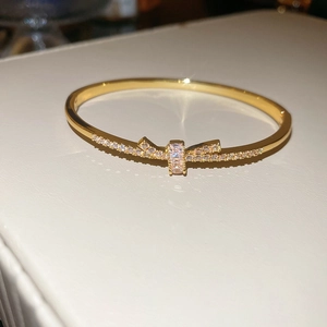 Vue macro du bracelet doré avec un nœud étincelant serti de zircons cubiques