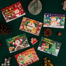 Flat lay of colorful 3D Christmas cards with Santa and reindeer on green background