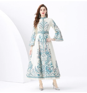 Detail of bohemian ivory maxi dress with intricate teal prints and a stand collar