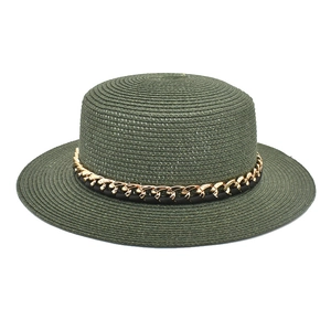 Vue détaillée du chapeau canotier vert foncé avec chaîne en métal doré et ruban tressé