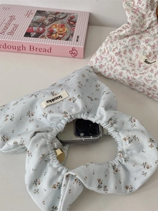 Floral canvas wristlet bag set showing capacity with phone and cosmetics inside
