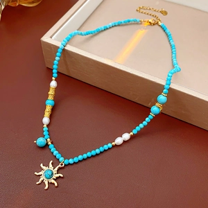 Détail du collier pendentif soleil vintage avec perles de turquoise et perles d'eau douce